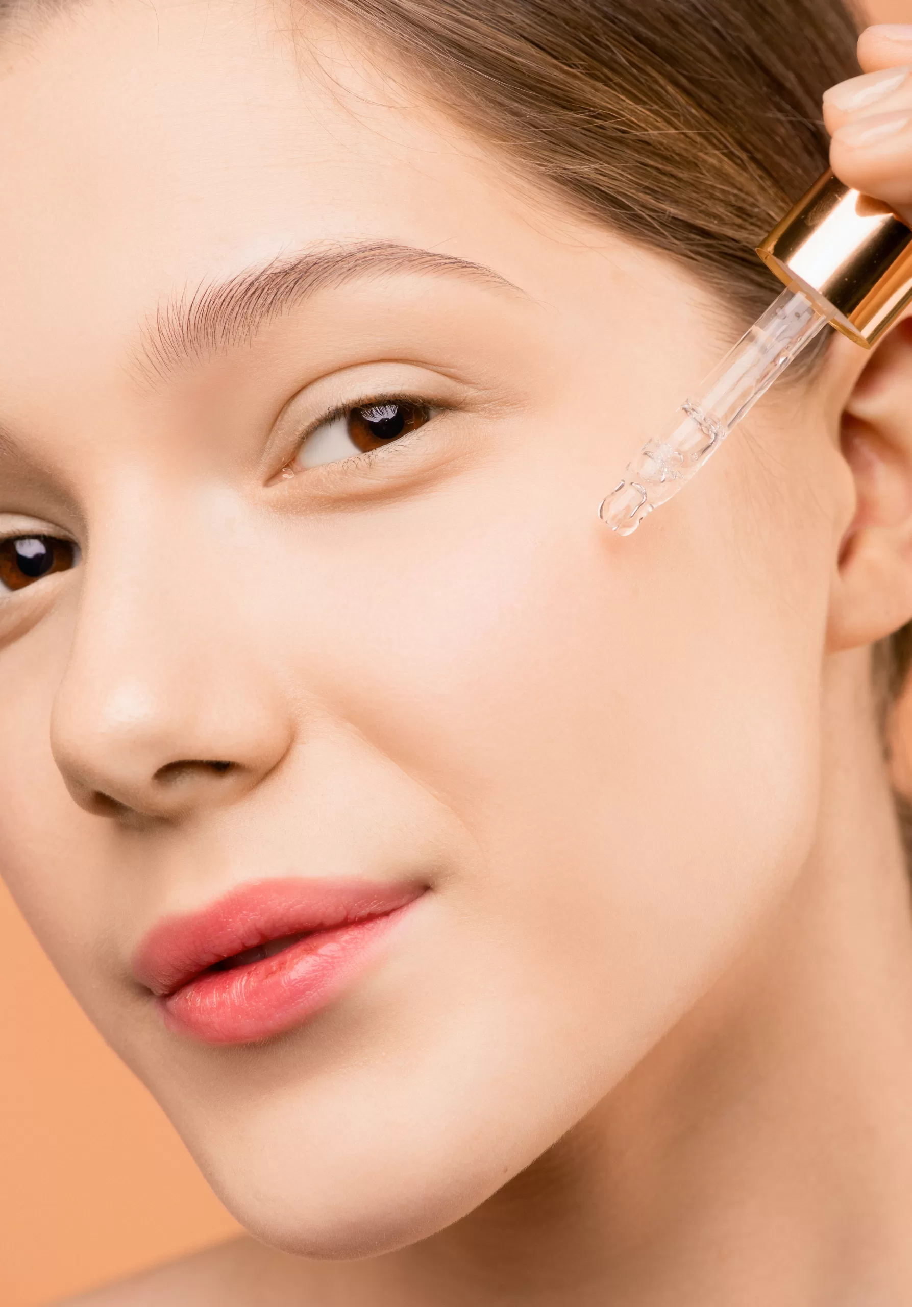 woman applying retinol dropper to face